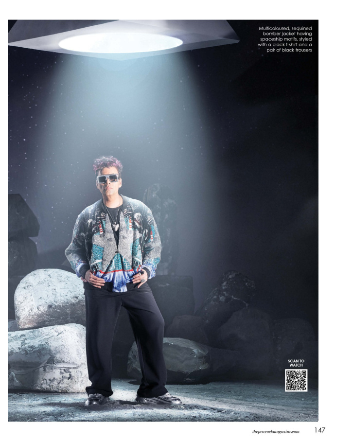Multicoloured, sequined bomber jacket having spaceship motifs, styled with a black t-shirt and a pair of black trousers