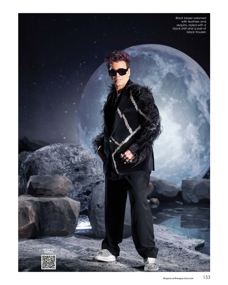Black blazer adorned with feathers and sequins, styled with a black shirt and a pair of black trousers